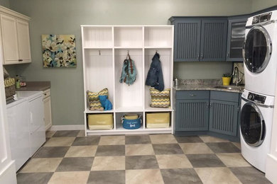 Diseño de cuarto de lavado actual con fregadero encastrado, puertas de armario azules, armarios con paneles empotrados y paredes grises