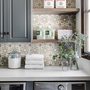 Inspiration for a mid-sized mediterranean single-wall travertine floor and beige floor dedicated laundry room remodel in Orange County with raised-panel cabinets, gray cabinets, quartz countertops, white walls, a side-by-side washer/dryer and gray countertops