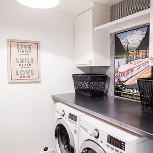 Inspiration för en mellanstor 50 tals parallell tvättstuga enbart för tvätt, med luckor med infälld panel, vita skåp, bänkskiva i rostfritt stål, vita väggar, klinkergolv i keramik och en tvättmaskin och torktumlare bredvid varandra