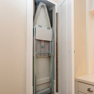 Foto di una sala lavanderia nordica di medie dimensioni con ante in stile shaker, ante bianche, top in laminato, pareti bianche, pavimento in gres porcellanato, lavatrice e asciugatrice affiancate e pavimento grigio