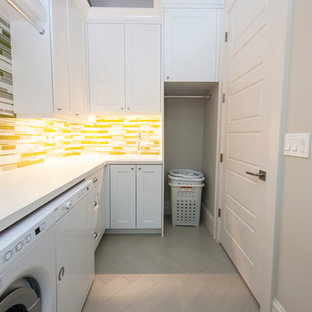 Ispirazione per una sala lavanderia nordica di medie dimensioni con ante in stile shaker, ante bianche, top in laminato, pareti bianche, pavimento in gres porcellanato, lavatrice e asciugatrice affiancate e pavimento grigio