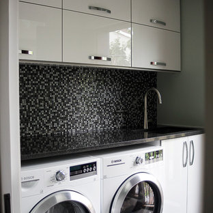 Inspiration för små linjära tvättstugor enbart för tvätt, med en nedsänkt diskho, släta luckor, vita skåp, bänkskiva i onyx, beige väggar och en tvättmaskin och torktumlare bredvid varandra