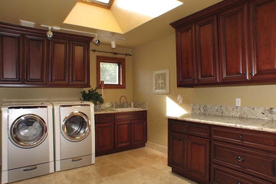 Dedicated laundry room - mid-sized traditional l-shaped ceramic tile dedicated laundry room idea in Sacramento with a drop-in sink, raised-panel cabinets, dark wood cabinets, granite countertops, beige walls and a side-by-side washer/dryer