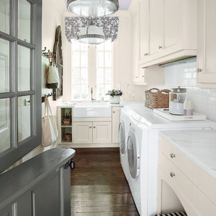 Esempio di una lavanderia classica con ante beige, lavello stile country, pavimento marrone e top bianco