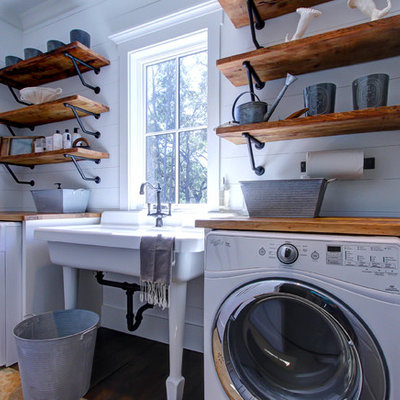 Example of a country single-wall dark wood floor dedicated laundry room design in Atlanta with an utility sink, shaker cabinets, white cabinets, wood countertops, white walls and brown countertops