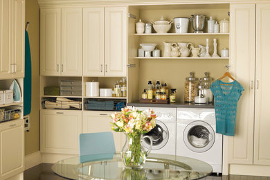 Foto di una grande lavanderia multiuso chic con ante con bugna sagomata, ante bianche, top in superficie solida, pareti beige, parquet scuro e lavatrice e asciugatrice affiancate