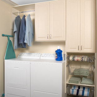 Bild på en mellanstor vintage linjär tvättstuga enbart för tvätt, med luckor med upphöjd panel, beige skåp, beige väggar, heltäckningsmatta, en tvättmaskin och torktumlare bredvid varandra och brunt golv