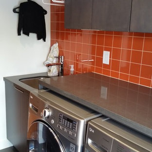Exemple d'une petit buanderie tendance avec un évier encastré, un placard à porte plane, un plan de travail en quartz, un mur blanc, un sol en bois foncé, des machines côte à côte, un sol noir, un plan de travail gris et des portes de placard grises.