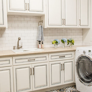 Inspiration for a large transitional l-shaped terra-cotta tile laundry closet remodel in Phoenix with an undermount sink, raised-panel cabinets, white cabinets, solid surface countertops, white walls and a side-by-side washer/dryer