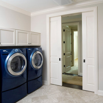Pocket doors lead to laundry room with blue Whirlpool Duet appliances