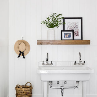 Idée de décoration pour une buanderie tradition avec un évier utilitaire, un mur blanc, un sol gris et du lambris de bois.