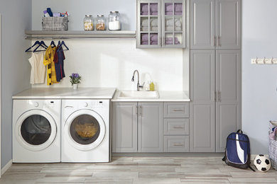 Example of a laundry room design in Chicago with a drop-in sink, gray cabinets, a side-by-side washer/dryer and white countertops