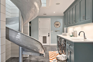 Large farmhouse single-wall separated utility room in Austin with a submerged sink, shaker cabinets, concrete flooring, a side by side washer and dryer, blue cabinets, marble worktops, blue walls, grey floors and white worktops.