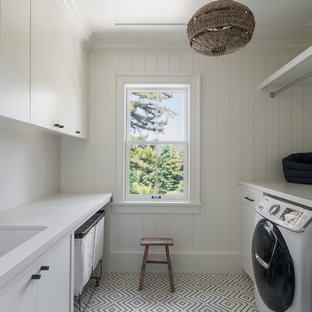 Ispirazione per una grande sala lavanderia minimal con lavello sottopiano, ante lisce, ante bianche, pareti bianche, pavimento bianco, top bianco, top in marmo, pavimento con piastrelle in ceramica e lavatrice e asciugatrice affiancate