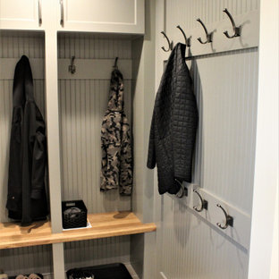 Exemple d'une grand buanderie chic en U multi-usage avec un évier encastré, un placard à porte plane, des portes de placard grises, un plan de travail en quartz modifié, une crédence grise, une crédence en carrelage de pierre, un mur gris, un sol en carrelage de porcelaine, des machines côte à côte, un sol gris et un plan de travail blanc.