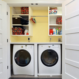 Example of a small minimalist single-wall light wood floor laundry closet design in Boston with open cabinets, yellow walls, a side-by-side washer/dryer and white cabinets