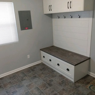 Réalisation d'une buanderie design avec un placard avec porte à panneau encastré, des portes de placard blanches, un plan de travail en stratifié, une crédence blanche, une crédence en lambris de bois, un mur gris, un sol en linoléum, un sol marron et un plan de travail marron.