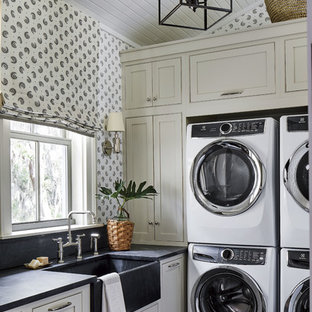 Immagine di una sala lavanderia stile marinaro con lavello stile country, ante in stile shaker, ante grigie, pareti multicolore, pavimento nero e top nero
