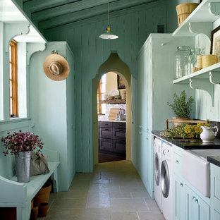 Idee per una lavanderia mediterranea con lavello stile country, pavimento grigio e top nero