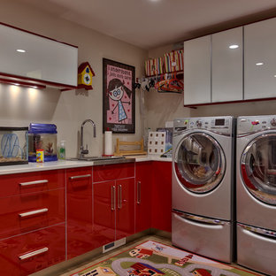 Immagine di una lavanderia design con lavello da incasso, ante lisce, ante rosse, pareti beige e lavatrice e asciugatrice affiancate