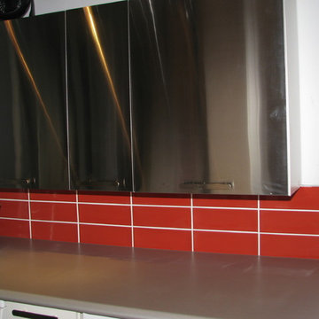 Stainless Cabinets with Orange Subway Tile