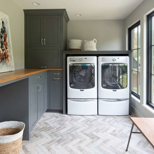 Idee per una sala lavanderia scandinava con ante grigie, top in legno, pavimento in gres porcellanato, lavatrice e asciugatrice affiancate, pavimento grigio, top marrone, ante in stile shaker e pareti grigie