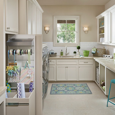 Inspiration for a large timeless u-shaped porcelain tile utility room remodel in Houston with a single-bowl sink, recessed-panel cabinets, white cabinets, limestone countertops, a side-by-side washer/dryer, beige walls and beige countertops