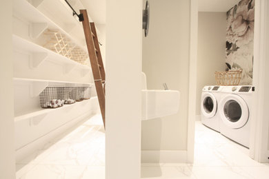 Laundry closet - contemporary marble floor and white floor laundry closet idea in Calgary with open cabinets, beige walls and a side-by-side washer/dryer