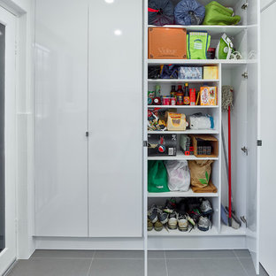 Inspiration för mellanstora moderna linjära tvättstugor enbart för tvätt, med en nedsänkt diskho, vita skåp, laminatbänkskiva, vita väggar och en tvättmaskin och torktumlare bredvid varandra
