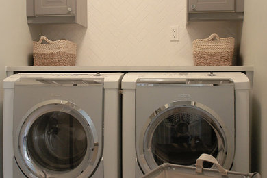 Dedicated laundry room - small traditional single-wall porcelain tile dedicated laundry room idea in Ottawa with raised-panel cabinets, gray cabinets, quartz countertops, gray walls and a side-by-side washer/dryer