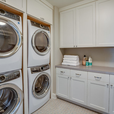 Dedicated laundry room - traditional beige floor dedicated laundry room idea in Minneapolis with shaker cabinets, white cabinets, gray walls, a stacked washer/dryer and gray countertops