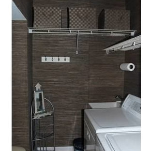 Bild på ett litet maritimt parallellt grovkök, med en allbänk, luckor med infälld panel, vita skåp, bänkskiva i koppar, blå väggar, vinylgolv och en tvättmaskin och torktumlare bredvid varandra