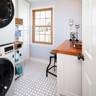 Idéer för att renovera en vintage bruna linjär brunt tvättstuga enbart för tvätt, med vita skåp, träbänkskiva, blå väggar, en tvättpelare och vitt golv