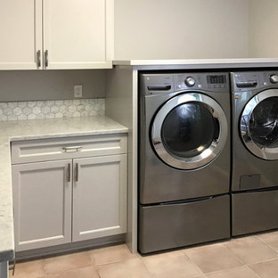Immagine di una sala lavanderia country di medie dimensioni con lavello a vasca singola, ante a filo, ante grigie, top in granito, pareti grigie, pavimento con piastrelle in ceramica, lavatrice e asciugatrice affiancate, pavimento rosa e top bianco