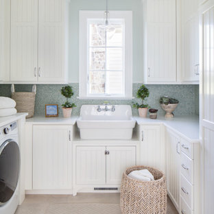 Réalisation d'une buanderie marine en U dédiée et de taille moyenne avec un évier de ferme, un placard à porte affleurante, des portes de placard blanches, un plan de travail en quartz, un mur vert, un sol en carrelage de porcelaine, des machines côte à côte et un plan de travail blanc.