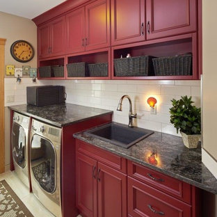 Esempio di una sala lavanderia country di medie dimensioni con lavello da incasso, ante con riquadro incassato, ante rosse, top in granito, pareti beige, pavimento in gres porcellanato, lavatrice e asciugatrice affiancate e pavimento beige