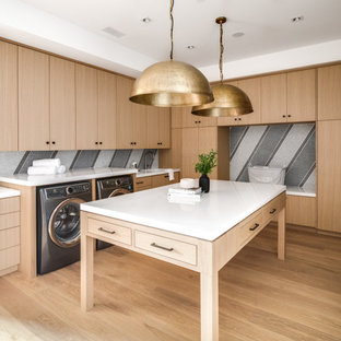 Esempio di una lavanderia multiuso moderna con lavello a vasca singola, ante lisce, ante in legno chiaro, pareti multicolore, parquet chiaro, lavatrice e asciugatrice affiancate, pavimento beige e top bianco