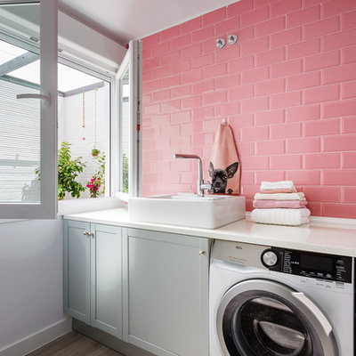 Example of a mid-sized trendy single-wall ceramic tile and gray floor dedicated laundry room design in Madrid with a single-bowl sink, gray cabinets, white walls, a side-by-side washer/dryer and shaker cabinets