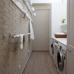 Exempel på en liten industriell beige parallell beige tvättstuga enbart för tvätt, med en integrerad diskho, luckor med infälld panel, vita skåp, bänkskiva i koppar, beige väggar, mellanmörkt trägolv, en tvättmaskin och torktumlare bredvid varandra och beiget golv