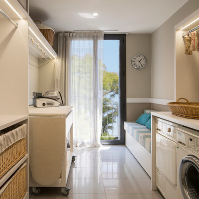 Mid-sized danish galley dedicated laundry room photo in Barcelona with open cabinets, a side-by-side washer/dryer and white cabinets
