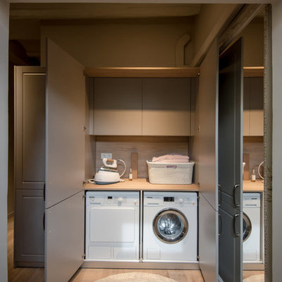 Example of a small transitional single-wall light wood floor and beige floor laundry closet design in Barcelona with flat-panel cabinets, a side-by-side washer/dryer, wood countertops, beige countertops and gray cabinets