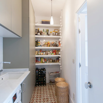 Utility room - mid-sized transitional single-wall ceramic tile utility room idea in Madrid with flat-panel cabinets, gray cabinets, marble countertops, white walls, a side-by-side washer/dryer and an undermount sink