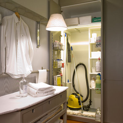 Dedicated laundry room - small traditional single-wall medium tone wood floor dedicated laundry room idea in Barcelona with flat-panel cabinets, beige walls and gray cabinets