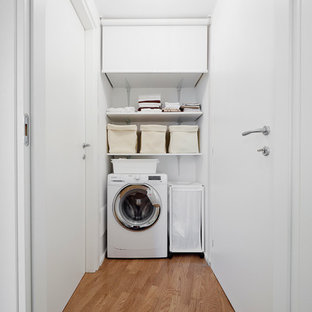 Idee per una sala lavanderia contemporanea con pareti bianche e pavimento in legno massello medio