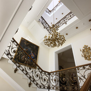 Foto de escalera en U, clásica renovada, grande, con escalones de mármol, contrahuellas de mármol y barandilla de varios materiales