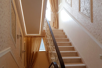 Imagen de escalera en U clásica de tamaño medio con escalones de mármol, contrahuellas de mármol y barandilla de metal