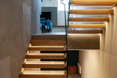 Modelo de escalera en U actual de tamaño medio sin contrahuella con escalones de madera y barandilla de vidrio