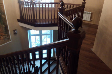 На фото: прямая деревянная лестница в классическом стиле с деревянными ступенями и деревянными перилами