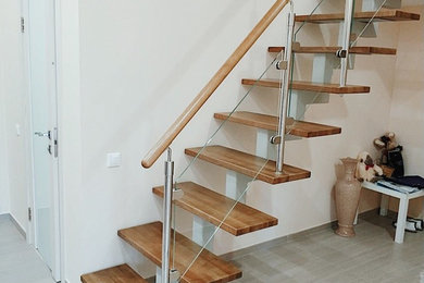 Стильный дизайн: прямая металлическая лестница среднего размера в современном стиле с деревянными ступенями и деревянными перилами - последний тренд
