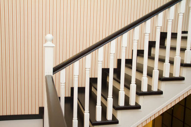 Imagen de escalera en U con escalones de madera, contrahuellas de madera y barandilla de madera